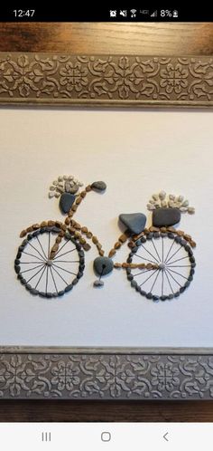 an image of a bike made out of wood beads on a white wall in a frame