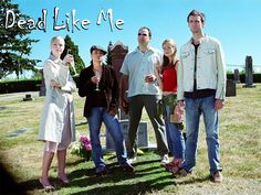 a group of people standing next to each other in front of a grave with flowers