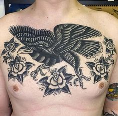 a man's chest with an eagle and roses tattoo design on his left side