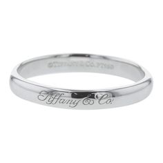 a white gold wedding band with the words, flying & co engraved on it's side