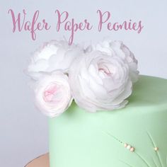 there is a green cake with white flowers on it and the words wider paper peonies