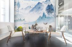 a room with a table and chairs in front of a wall mural that has deers on it