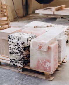 several different types of soaps sitting on pallets in a room with wooden crates