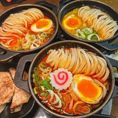 four pans filled with different types of food on top of a stove burner