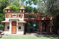 an outdoor play area with a tree house and slide