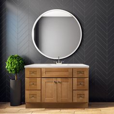 a bathroom vanity with a round mirror above it and a potted plant next to it