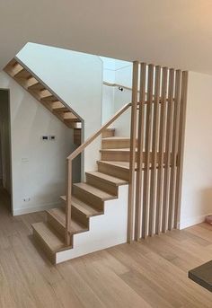 there is a wooden stair case in the room with white walls and wood flooring