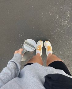 a person standing next to a parking meter with their feet on the ground and one foot in the air