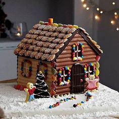 a gingerbread house decorated with candy and candies on top of snow covered ground