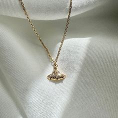 The centerpiece of this necklace is a petite UFO charm. The UFO's sleek and minimalist design adds a touch of whimsy and intrigue, making it a conversation starter wherever you go. It's a playful nod to the wonders of the universe and the endless possibilities that lie beyond our world. Order yours today and let your style soar to new heights with a touch of intergalactic elegance.  Finish: Gold Dipped Adjustable Chain 16 to 18 inches This necklace is ready to ship in 1 - 2 business days To ensure lasting beauty and shine, follow these simple care instructions: * Avoid Contact with Water: Remove your necklace before swimming, showering, or participating in water-related activities. * Avoid Harsh Chemicals and Clean Gently: If your necklace needs cleaning, use a soft, damp cloth to gently w Pearl Spaceship Necklace, Spaceship Necklace, Space-themed Pendant Necklace As Gift, Silver Saturn Necklace, Plane Necklace, Ufo Jewelry, Alien Necklace, Gifts Fo, Gold Dipped