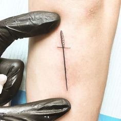 a woman's arm with a small cross tattoo on the left side of her body