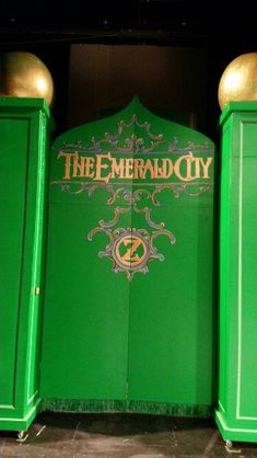 the emerald city sign is on display in front of two tall green pillars with gold accents