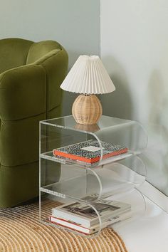 a lamp sitting on top of a table next to a green chair and a couch