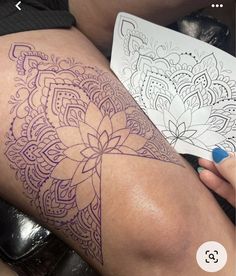 a woman's thigh with an intricate tattoo design on it