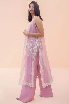 This powder pink sleeveless organza cape with block print is the perfect embodiment of modern chic. The piece has an embroidered bird motif that adds to its simplistic appeal. The cape is paired with a matching choli with a diamante embellished strap and matching raw silk bootleg trousers. Kurti With Piping Design, Modern Indian Outfits Casual, Modern Indian Fashion, Fashion Outfits Indian, Organza Salwar, Organza Cape, Sania Maskatiya, Casual Indian Fashion, Embroidered Bird