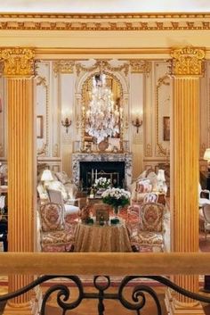 a living room filled with lots of furniture and a chandelier