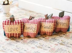 three apples with the words love, family, and apples written on them sitting on a table