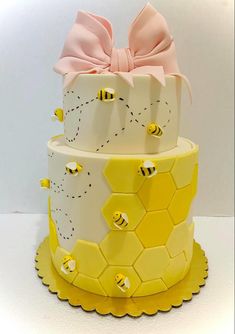 a three tiered cake decorated with honeycombs and a pink bow