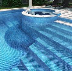 an empty swimming pool with lounge chairs around it