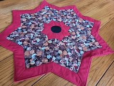 a pink and black star shaped object sitting on top of a wooden floor