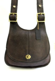 before you is a wonderful,   very RARE classic Coach crescent saddle  bag,   made in the early 1970's in New York City.    this rare vintage shoulder flap bag would work well for around town or a day of shopping,   classic.       made  of very sturdy brown leather,   a rare vintage find.     timeless.       at about 10 inches  wide across the bottom,   and about 10 inches tall.   the strap can be adjusted.   there is a  zip pocket inside.    for vintage (over 50 years old)  this bag is in decent Classic Saddle Bag With Brass Hardware, Classic Brown Saddle Bag, Brown Saddle Bag With Brass Hardware, Vintage Brown Saddle Bag With Leather Backing, Vintage Leather Saddle Bag With Gold-tone Hardware, Everyday Vintage Saddle Bag With Leather Backing, Vintage Brown Saddle Bag For Formal Occasions, Vintage Brown Saddle Bag With Brass Hardware, Vintage Brown Saddle Bag With Soft Leather