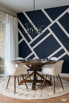 a dining room table with four chairs and a chandelier hanging from the ceiling