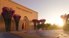 the entrance to a large building with pink flowers on it's front and side