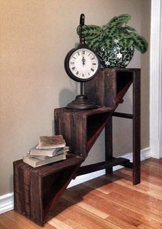 a clock sitting on top of a wooden shelf next to a potted plant and books