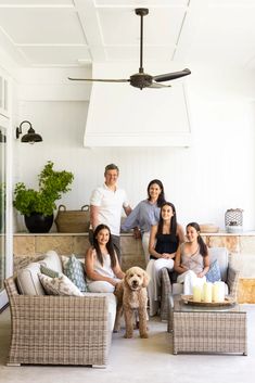 a group of people sitting on top of couches in front of a ceiling fan