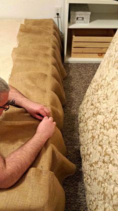 a man laying on the ground next to a bed