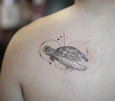 a tattoo on the back of a man's shoulder with a turtle in it