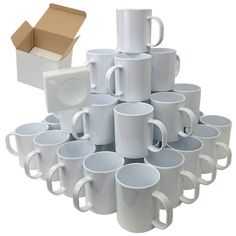 a stack of white coffee mugs sitting next to a cardboard box