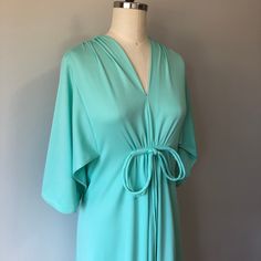 "A lovely comfortable style vintage dress in perfect condition! Hidden zipper down the back and a bow detail in the front. The Sleeves have a beautiful flowy elegant style to them. Size: S/M Tag - none Era - 60s Material - polyester, nylon zipper, metal hook and eye Bust - 32 to 34\" Waist - 26 to 28\" Hips - 35 to 37\" comfortably Length - 44\" Washing - cold delicate cycle in laundry bag or hand wash/lightly steam clean" Retro V-neck Wedding Dress, 60s Fashion Dresses, Teal Green Dress, Vintage Green Dress, Vintage 60s Dress, Silver Evening Dress, Vintage Dress 60s, Vintage Black Dress, Boho Beauty