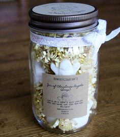 a jar filled with lots of white flowers on top of a wooden table