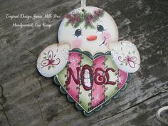 a ceramic ornament with the word noel on it's face and two hearts