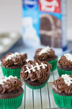 cupcakes with chocolate frosting and white crosses on them sitting on a cooling rack