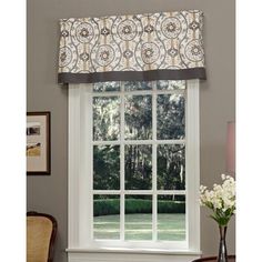 a living room with a window covered in valance and curtains over the top of it