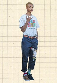 a man standing in front of a tiled wall with his hand up to his mouth