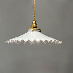 a white glass light hanging from a ceiling