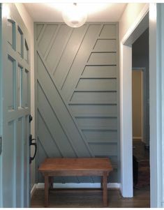 a wooden bench sitting in the middle of a hallway next to a door and window