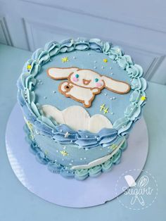 a blue cake decorated with an image of a bunny in the sky and stars on it