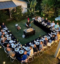 a group of people sitting around a table with plates and food in the shape of a heart