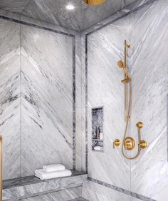 a walk in shower sitting next to a toilet and bathtub with gold fixtures on the walls