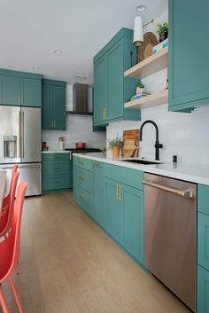 a kitchen with teal cabinets and stainless steel appliances