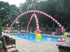 an outdoor pool decorated with balloons and streamers