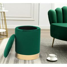 a living room with green chairs and a gold coffee cup on the floor next to it