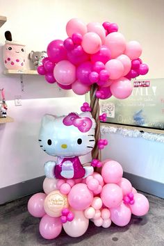 a hello kitty balloon tree with pink and white balloons