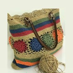 a crocheted bag with a ball of yarn next to it