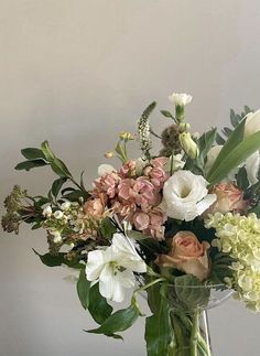 a vase filled with lots of flowers on top of a table