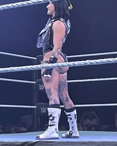 a female wrestler standing in the middle of a ring